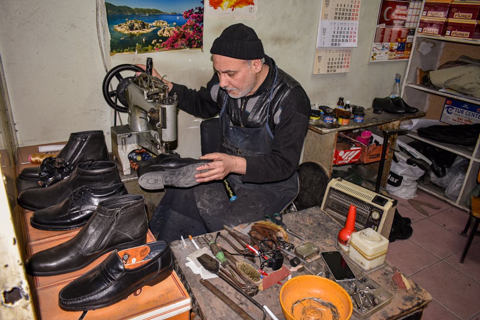 A cobbler meticulously repairs leather shoes in a traditional workshop setting.